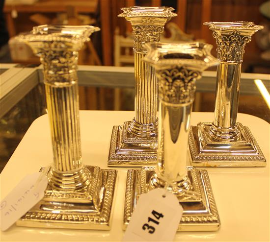 Two pairs of silver pillar candlesticks